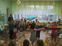 на фотографии дети и библиотекарь детского отдела играют в башкирскую игру Юрта