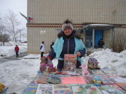 На фото Валентина Михайловна Богомолова, заведующая библиотекой с выставкой книг на масленице